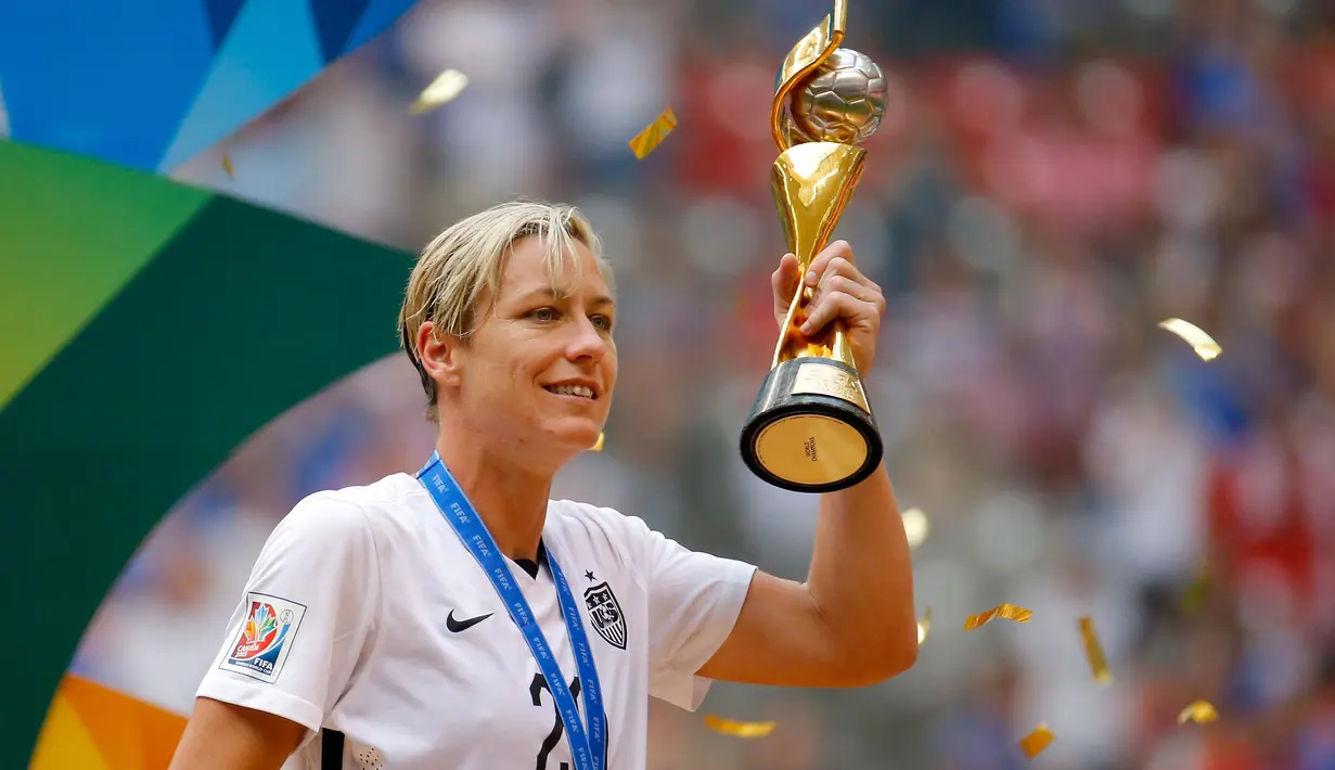 Abby Wambach, pemain timnas sepak bola wanita Amerika Serikat saat mengangkat Piala Dunia 2015 di Kanada. Abby diperkirakan menerima bayaran sebesar $190.000 sampai $300.000. (Getty Images/AFP/Kevin Cox)
