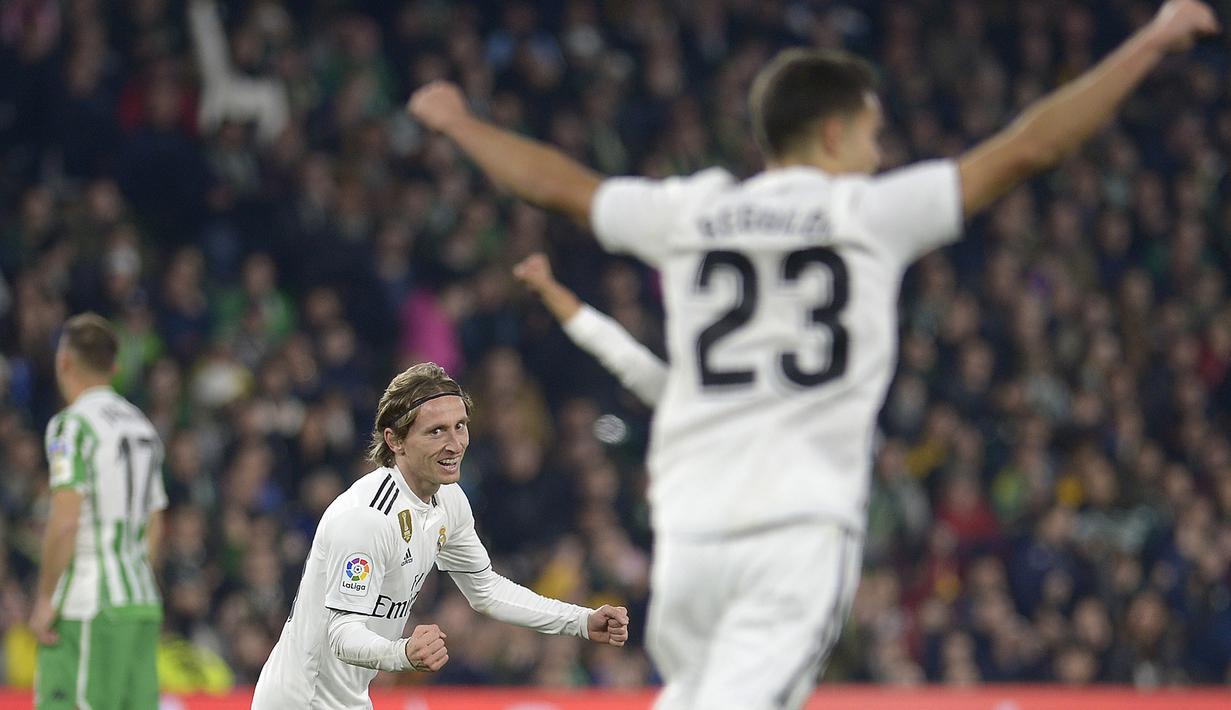 Selebrasi Luka Modric usai mencetak gol ke gawang Real Betis pada laga lanjutan La Liga Spanyol yang berlangsung di stadion Benito Villamarin, Senin (14/1). Real Madrid menang 2-1 atas Real Betis. (AFP/Cristina Quicler)