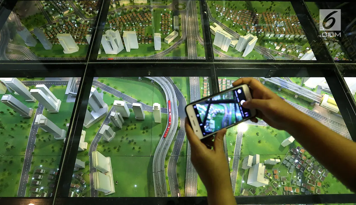 Pengunjung mengabadikan gambar LRT city pada pameran Indonesia Property Expo 2018 di JCC Jakarta, Senin (24/9). Dua anak usaha PT Adhi Karya (Persero) Tbk akan membangun 2.668 unit di LRT City Green Avenue, Bekasi Timur. (Liputan6.com/Fery Pradolo)