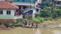 Warga dan petugas dari BPBD Kota Bogor memantau kemunculan buaya di Sungai Cisadane, Kelurahan Rangga Mekar, Kecamatan Bogor Selatan. (Liputan6.com/Achmad Sudarno)