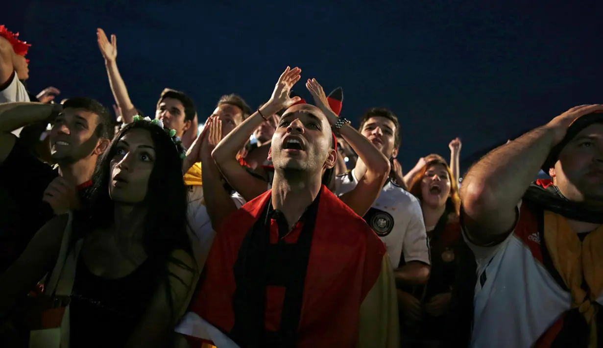 Beberapa kali para suporter Jerman harus menahan nafas saat menyaksikan laga Jerman kontra Aljazair melalui layar lebar di pantai Copacabana, Rio de Janeiro, (1/7/2014). (REUTERS/Pilar Olivares)