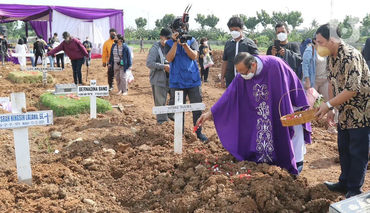 Uskup Ignatius Kardinal Suharyo menabur bunga di atas makamsaat memimpin misa perayaan ekaristi peringatan arwah bagi korban Covid-19 di area TPU Rorotan, Jakarta Utara, Selasa (30/11/2021). Perayaan misa tersebut digelar di area pemakaman khusus Covid-19 TPU Rorotan (Liputan6.com/Herman Zakharia)