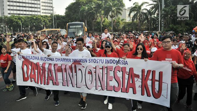 Umat lintas agama membentangkan spanduk saat Gerak Jalan Kerukunan Umat Beragama di kawasan Car Free Day, Jakarta, Minggu (21/10). Dalam kesempatan itu, perwakilan lintas agama juga mendeklarasikan pelaksanaan pemilu damai. (Merdeka.com/ Iqbal S. Nugroho)