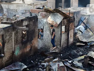 Warga mencari barang-barang dari bangunan pascakebakaran yang melanda kawasan pemukiman di Jalan Manggarai Utara, Jakarta, Kamis (14/12/2023). (Liputan6.com/Herman Zakharia)