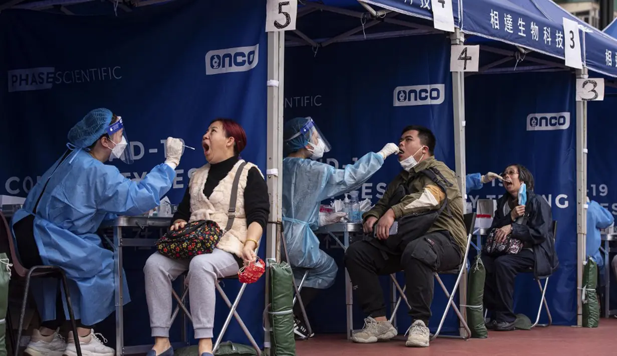 Orang-orang melakukan pengujian virus corona COVID-19 di Hong Kong, 12 Februari 2022. Pihak berwenang bergegas untuk meningkatkan kapasitas pengujian COVID-19 menyusul rekor tertinggi infeksi baru. (Louise Delmotte/AFP)