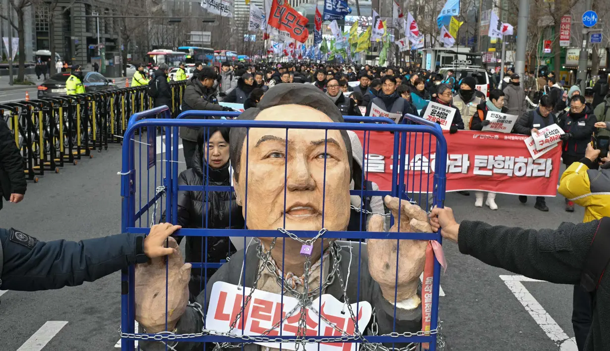 Dalam aksinya, para pengunjuk rasa juga membawa poster bergambar Presiden Yoon Suk Yeol yang terborgol dan terpenjara. (ANTHONY WALLACE/AFP)
