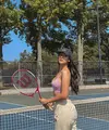Padanan crop tank top dengan track pants warna krem menjadi pilihan outfit tenis Anya Geraldine.