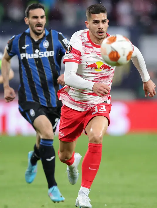 Pemain depan RB Leipzig Andre Silva (kanan) berlari mengejar bola di depan bek Atalanta Davide Zappacosta pada leg pertama perempatfinal Liga Europa di Red Bull Arena, Kamis (7/4/2022). Atalanta bermain imbang 1-1 dengan RB Leipzig. (Ronny HARTMANN / AFP)