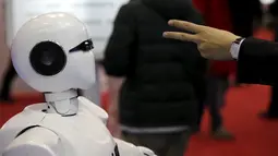 Pengunjung saat berinteraksi dengan KINGER pada Pameran Dunia Robot selama Konferensi Robot Dunia di Beijing, Cina,  (24/11). Selain pameran robot, Acara ini juga mengadakan kontes robot bagi para pelajar dan pemuda. (REUTERS/Jason Lee)