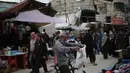 Warga berusaha mempersiapkan kebutuhan lebaran di tengah keterbatasan. Tampak dalam foto, seorang pria Palestina pengungsi melihat sebuah kemeja di pasar jalanan sekitar kamp pengungsi Nuseirat, Jalur Gaza tengah, pada Rabu 18 Maret 2026. (Eyad Baba/AFP)