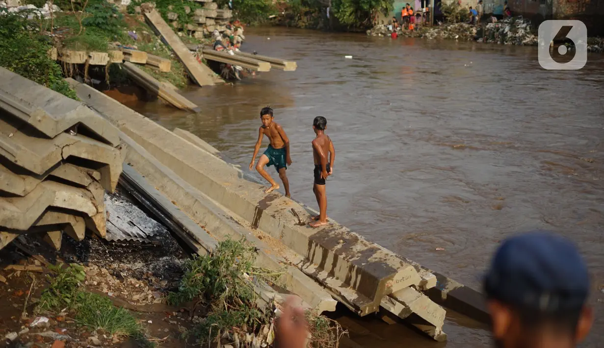 Anak-anak berenang di bantaran Sungai Ciliwung, Jakarta, Senin (5/10/2020). Derasnya aliran Sungai Ciliwung akibat hujan deras yang mengguyur Jakarta tidak menyurutkan kemauan anak-anak tersebut untuk tetap berenang, meski dapat membahayakan keselamatan mereka. (Liputan6.com/Immanuel Antonius)