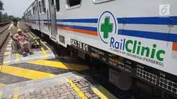 Petugas membantu seorang ibu yang ingin berobat ke Rail Clinic yang berhenti di Stasiun Alastua, Semarang, Jawa Tengah, Kamis ( 28/3). Pengobatan gratis dari PT KAI ini dihadiri oleh ratusan warga sekitar stasiun. (Liputan6.com/Gholib)