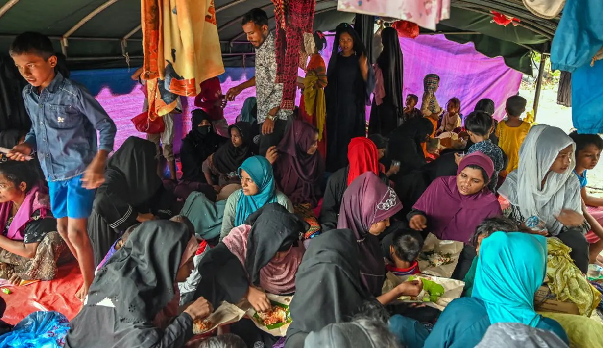 Dalam rombongan terlihat pengungsi laki laki dan perempuan dewasa serta anak-anak. (CHAIDEER MAHYUDDIN/AFP)