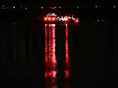 Sebuah kapal berisi tim penyelamat mencari korban di perairan Sungai Potomac, Washington DC, Amerika Serikat (AS), 30 Januari 2025. (ANDREW CABALLERO-REYNOLDS/AFP)