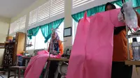 Para guru SMKN 5 Palu menunjukkan APD medis produksi mereka untuk dipasok ke rumah sakit rujukan covid-19 di Palu. (Foto: Liputan6.com/ Heri Susanto).
