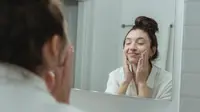 Ilustrasi perempuan yang sedang mencuci wajah menggunakan sabun cuci muka untuk kulit kering dan beruntusan. Credits: pexels.com by&nbsp;Miriam Alonso