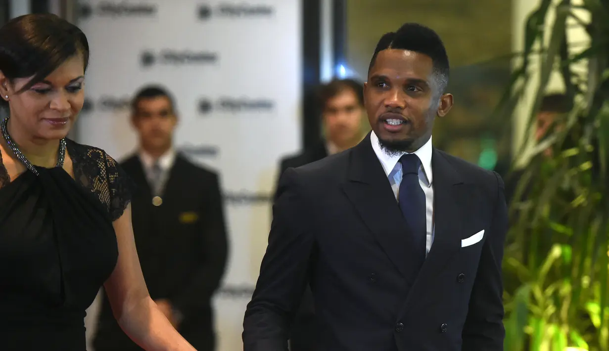 Mantan pemain Barcelona, Samuel Eto'o bersama istrinya saat menghadiri pernikahan Lionel Messi di Rosario, Argentina (30/6). (AFP Photo/Eitan Abramovich)
