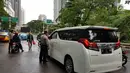Petugas kepolisian memberikan informasi lalu lintas kepada pengemudi usai balkon BEI ambruk di kawasan SCBD, Jakarta, Senin (15/1). (Liputan6.com/Herman Zakharia)