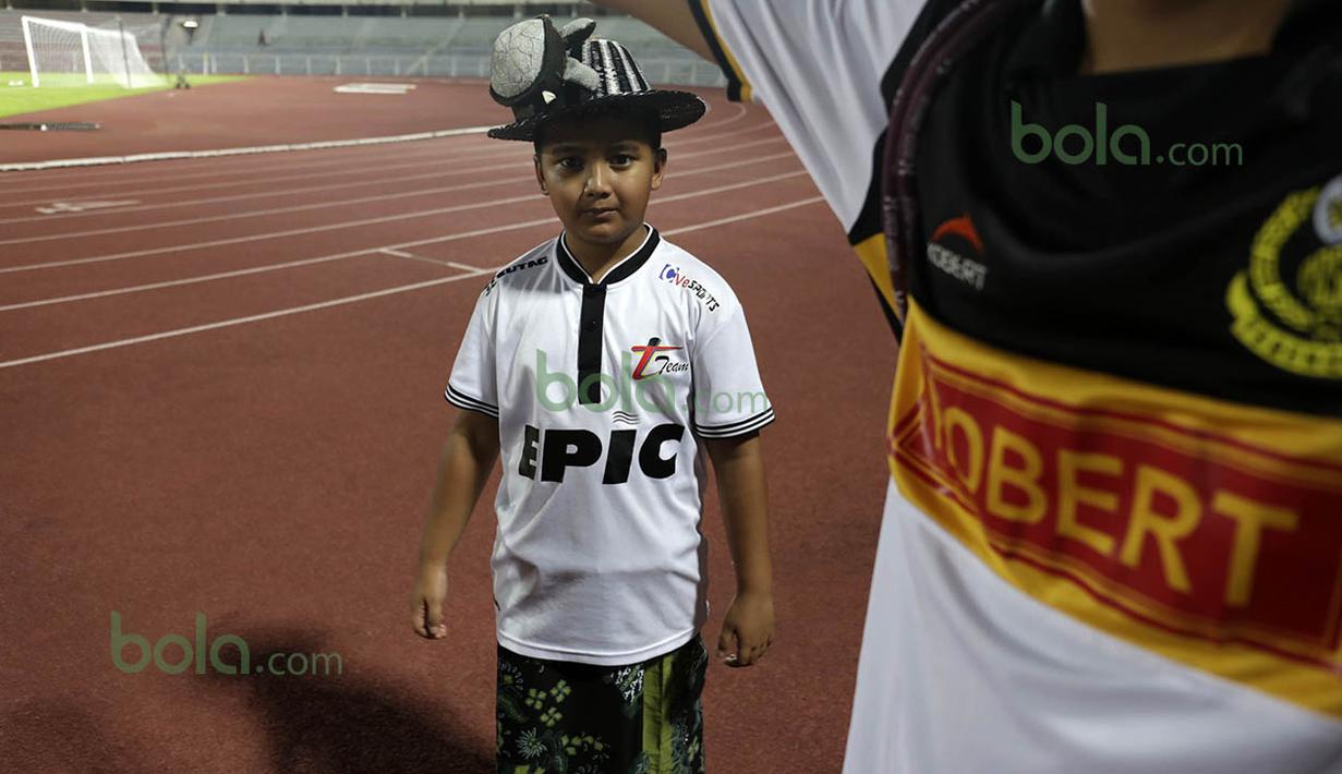 Suporter cilik dengan sarung batik ikut mendukung T-Team saat berlaga pada babak play-off melawan ATM FA di Stadion Perak, Malaysia, Sabtu (30/01/2016). (Bola.com/Nicklas Hanoatubun)