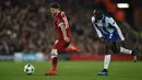 Bek Liverpool, Alberto Moreno berebut bola dengan striker FC Porto Vincent Aboubakar pada leg kedua babak 16 besar Liga Champions di Stadion Anfield, Selasa (6/3). Liverpool lolos ke perempatfinal berbekal kemenangan 5-0 secara agregat. (PAUL ELLIS/AFP)