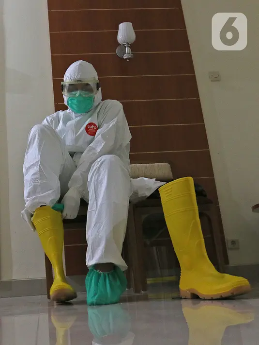 dr Rahmadi Iwan Guntoro, Sp.P memakai sepatu boots di Rumah Sakit Haji, Jakarta, Kamis (9/4/2020). Gugus Tugas Percepatan Penanganan COVID-19 telah mengeluarkan rekomendasi standar APD berdasarkan tiga tingkatan perlindungan. (Liputan6.com/Herman Zakharia)
