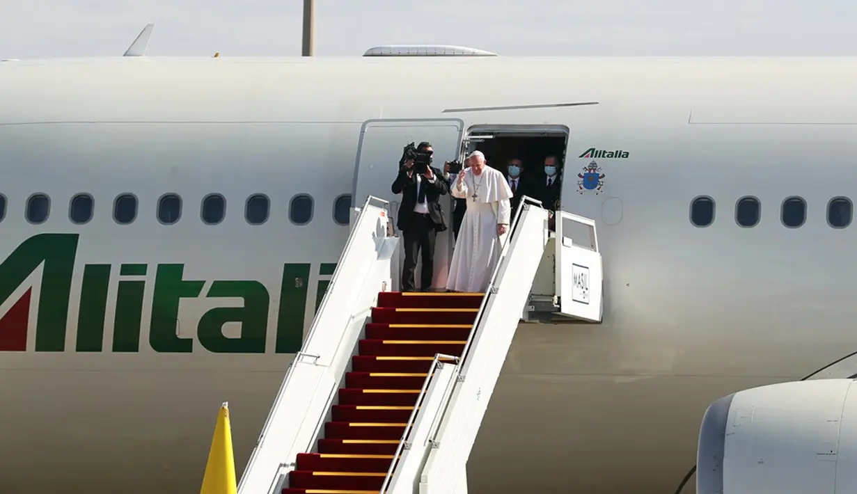 Paus Fransiskus naik pesawat setelah mengakhiri kunjungannya ke Irak di Bandara Baghdad, Irak, Senin (8/3/2021). Paus meninggalkan Irak usai membawa harapan kepada minoritas Kristen yang terpinggirkan di negara itu dengan pesan koeksistensi, pengampunan, dan perdamaian. (AP Photo/Khalid Mohammed)
