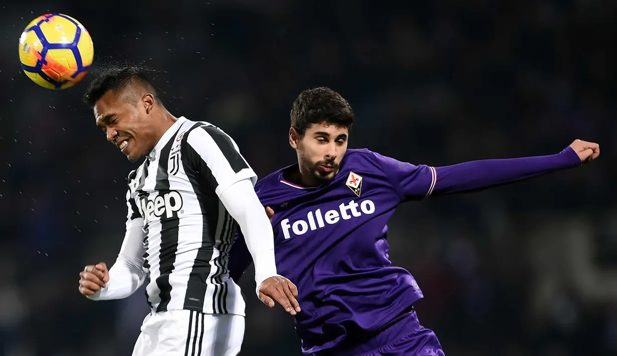 Bek Juventus, Alex Sandro (kiri) berebut bola udara dengan pemain Fiorentina, Gil Dias saat bertanding pada lanjutan Liga Serie A Italia di stadion Atemio Franchi, Florence (9/2). Juventus menang 2-0. (AFP Photo/Filippo Monteforte)