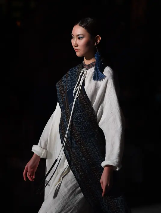 Seorang model memeragakan kreasi busana yang terbuat dari brokat Li, pakaian tradisional yang dibuat oleh kelompok etnis Li, dalam sebuah peragaan busana di Haikou, Provinsi Hainan, China selatan, pada 19 November 2020. (Xinhua/Guo Cheng)