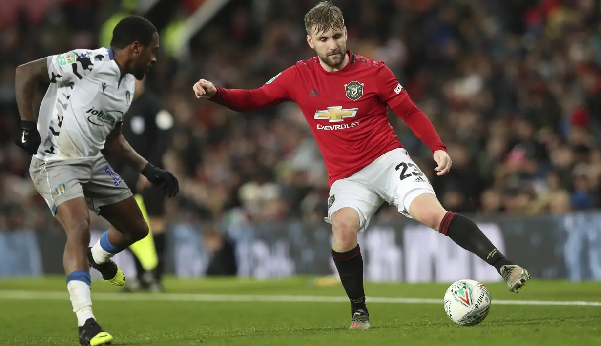 Bek Manchester United, Luke Shaw berusaha melewati pemain Colchester United, Diaz Wright pada pertandingan perempat final Piala Liga Inggris di Old Trafford (18/12/2019). Di semifinal, MU akan bertemu Manchester City. (AP Photo/Jon Super)