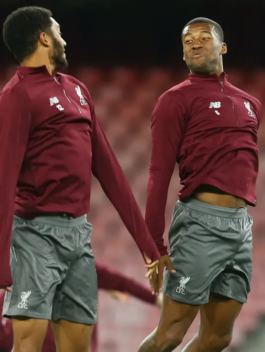 Bek Liverpool, Joe Gomez (kiri) dan gelandang Georginio Wijnaldum bercanda saat melakukan pemanasan jelang menghadapi Napoli pada grup C Liga Champions di stadion San Paolo di Naples, Italia (2/10). (AFP Photo/Carlo Hermann)