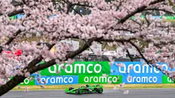 Pembalap Kick Sauber, Zhou Guanyu terlihat memacu mobilnya di antara ranting pohon sakura saat melakukan latihan bebas pertama (FP1) F1 GP Jepang 2024 di Sirkuit Suzuka, Jepang, Jumat (05/04/2024). (AFP/Yuichi Yamazaki)