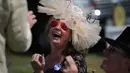 Seorang wanita tertawa saat makan siang di tempat parkir menjelang balap kuda di Ascot, London, (20/6). Mereka tampil gaya saat menyaksikan kompetisi balap kuda ini. (AFP Photo/Daniel Leal-Olivas)