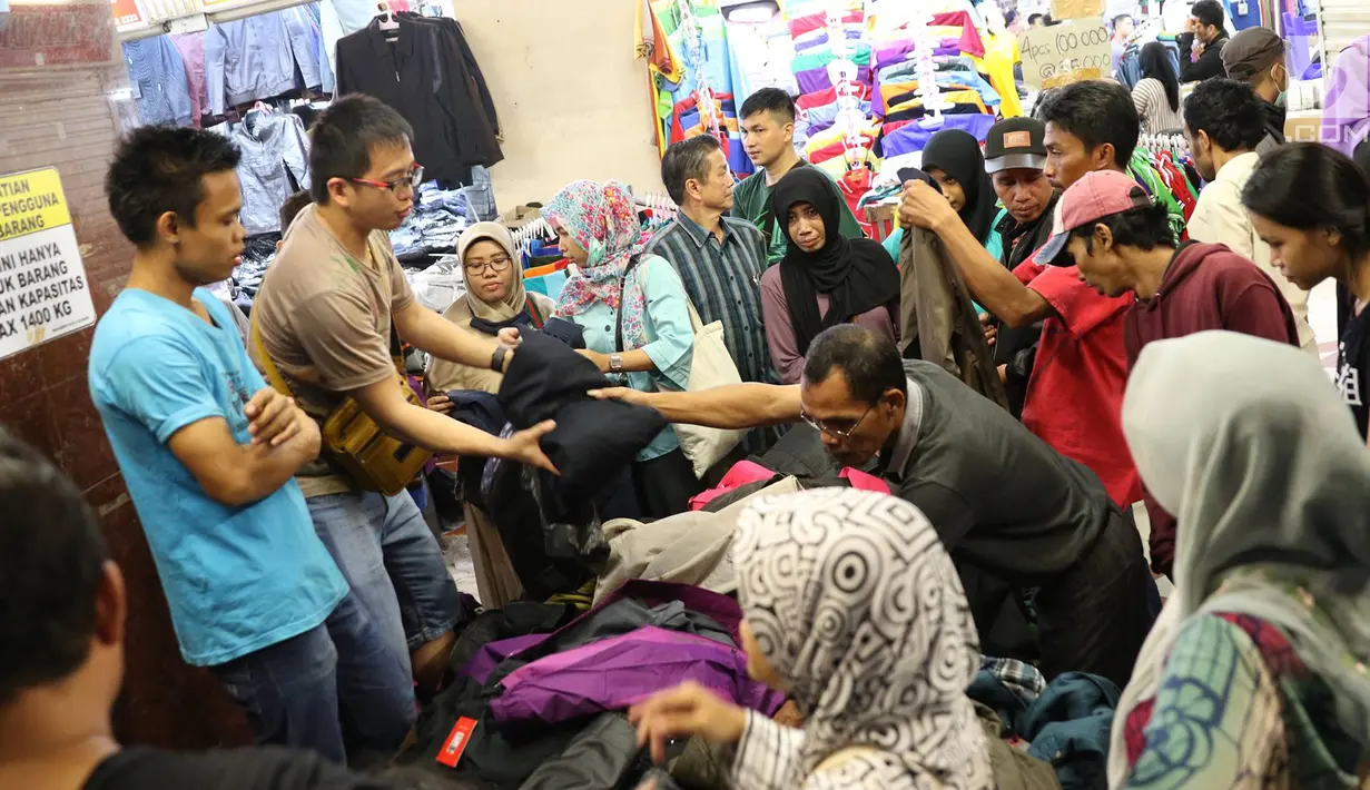 Pedagang melayani pembelinya di Pasar Tanah Abang, Jakarta, Minggu (18/6). Karena ramainya, terlihat di setiap sudut toko para pedagang tengah sibuk melayani para calon pembeli. (Liputan6.com/Immanuel Antonius)