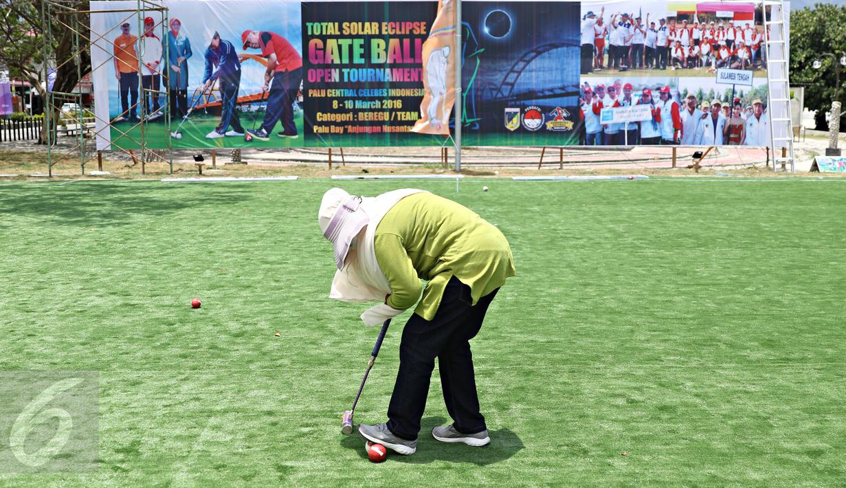 Seorang wisatawan bermain olahraga gateball di Pantai Talise, Palu, Sulawesi Tengah, Selasa (8/3). Event olahraga itu diadakan untuk memeriahkan acara melihat Gerhana Matahari Total bersama yang akan diadakan Rabu (9/3). (Liputan6.com/Immanuel Antonius)