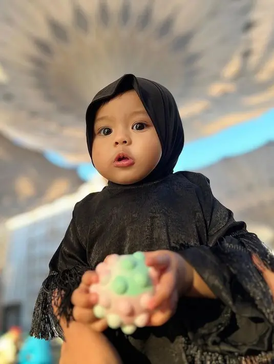 Baby Ameena tidak kalah mencuri perhatian dibanding bundanya. Ameena yang belum lama ini merayakan ulang tahun pertama itu tampil menggemaskan dengan hijab. [Instagram/attahalilintar]