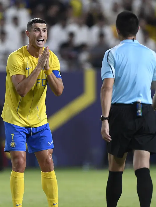 Pemain Al-Nassr, Cristiano Ronaldo (kiri) melakukan protes terhadap keputusan wasit yang memimpin laga play off Liga Champions Asia 2023/2024 antara Al-Nassr melawan Al-Ahli Dubai di KSU Stadium, Rabu (23/8/2023) WIB. (AFP/Yazid al-Duwihi)