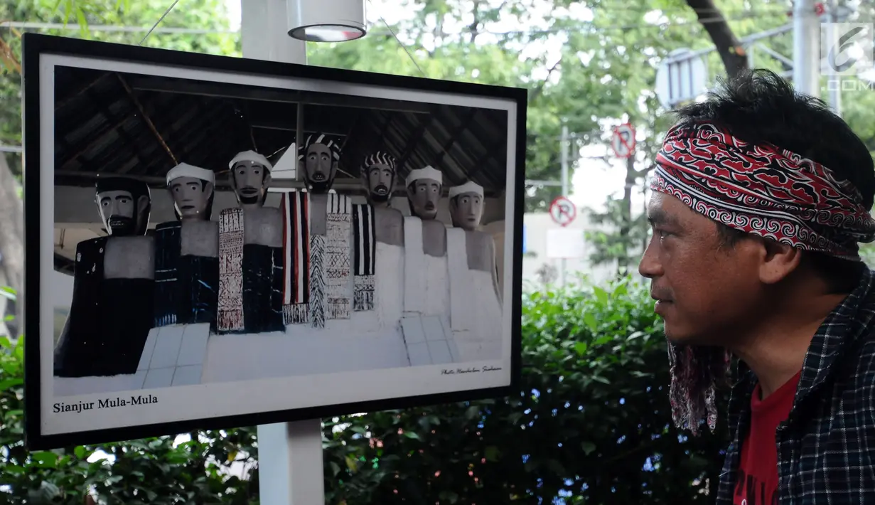 Pengunjung melihat foto yang dipamerkan saat Peluncuran Buku Danau Toba dan Mangongkal Holi di Jakarta, Kamis (24/8). Pameran foto menampilkan kehidupan masyarakat dan budaya Batak. (LIputan6.com/Helmi Fithriansyah)