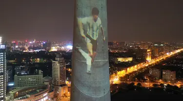 Foto dari udara menunjukkan gambar legenda sepak bola Diego Maradona yang diproyeksikan di Menara TV Tianjin di Kota Tianjin, China utara (26/11/2020). Maradona tutup usia di usia 60 tahun akibat serangan jantung pada Rabu (25/11). (Xinhua/Li Ran)