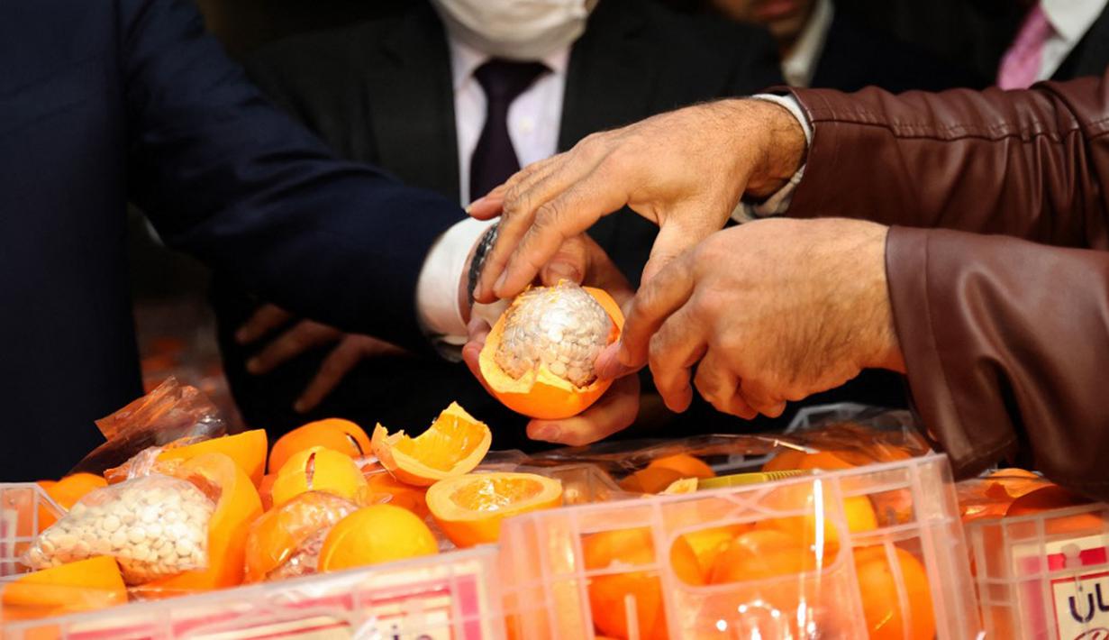 Seorang pria menunjukkan jeruk palsu berisi pil Captagon di Pelabuhan Beirut, Lebanon, 29 Desember 2021. Bea Cukai Lebanon menyita sembilan juta pil Captagon dalam jeruk palsu yang ditujukan ke salah satu negara Teluk. (ANWAR AMRO/AFP)