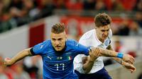 Pemain timnas Italia, Ciro Immobile berebut bola dengan pemain timnas Inggris, John Stone dalam laga persahabatan di Stadion Wembley, Rabu (28/3).  Sempat tertinggal, Italia menahan imbang Inggris 1-1. (AP Photo/Alastair Grant)