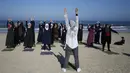 Sejumlah wanita Palestina berlatih yoga di pantai di Gaza City (3/3/2020). Pelatihan yoga tersebut diselenggarakan oleh Positive Energy Club. (AFP Photo/Mohammed Abed)