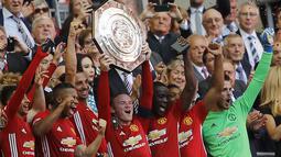 Para pemain Manchester United mengangkat trofi juara saat mengalahkan Leicester City 2-1 pada ajang Community Shield di Stadion Wembley stadium, London, Minggu (7/8/2016). (AP Photo/Frank Augstein)