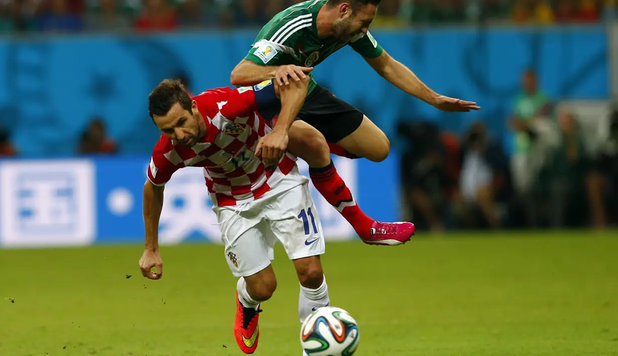 Gelandang Kroasia, Darijo Srna (kiri) berebut bola dengan pemain belakang Meksiko, Miguel Layun, di laga penutup penyisihan Piala Dunia Grup A di Stadion Pernambuco, Recife, Brasil, (24/6/2014). (REUTERS/Eddie Keogh)