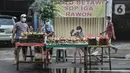 Pedagang melayani pembeli ketupat matang di jalan kawasan Rawamangun, Jakarta, Senin (19/7/2021). Pedagang membanderol ketupat siap santap tersebut mulai dari harga Rp30 ribu hingga Rp40 ribu per ikat (10 buah) tergantung besar kecil ukuran. (merdeka.com/Iqbal S. Nugroho)