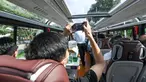 Seorang pria mengambil foto di dalam sebuah bus wisata di Shenzhen, Provinsi Guangdong, China selatan (22/10/2020). Shenzhen pada Kamis (22/10) meluncurkan tiga jalur bus wisata bagi wisatawan, yang masing-masing menampilkan budaya, teknologi, dan pemandangan malam kota tersebut. (Xinhua/Mao Siqian)