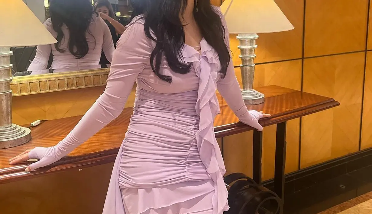 Cantiknya Hesti dengan mini dress berwarna ungu muda ini. Dress ini memiliki aksen kerut dan lengan panjang yang membentuk tubuhnya dengan amat baik. [Foto: Instagram/hestipurwadinata]