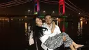 Mereka selfi dengan latar belakang panorama Jembatan Ampera. Asyraf terlihat membopong Tya. Mereka kompak mengumbar senyum. (Via Instagram/@tyaarifinnw)