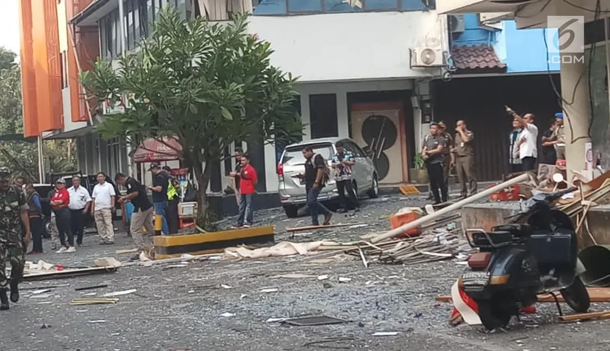 Seorang petugas berjaga di lokasi ledakan yang terjadi di kawasan Ruko Grand Wijaya, Kebayoran Baru, Jakarta Selatan, Kamis (12/7). Polisi sudah memasang garis polisi agar area lokasi kejadian steril dan tidak dilintasi warga (Liputan6.com/Ady Anugrahadi)