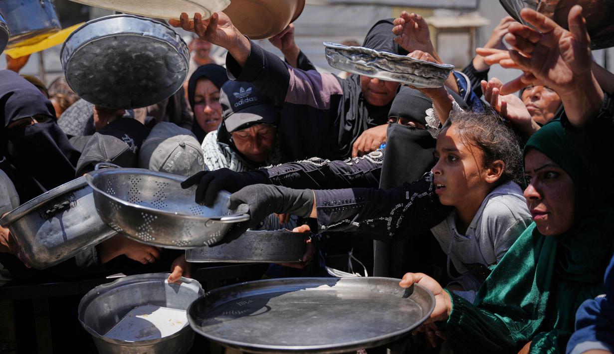 Warga Palestina menunggu untuk menerima makanan sumbangan di pusat distribusi di Khan Younis, Jalur Gaza, Rabu 27 Mei 2026. (AP Photo/Abdel Kareem Hana)