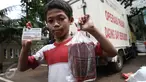 Seorang anak memperlihatkan daging beku yang baru dibeli pada operasi pasar murah di Kantor Kecamatan Matraman, Jakarta, Senin (27/6). Operasi pasar ini menjual daging sapi & ayam murah kepada pemegang KJP Sekolah Dasar (SD). (Liputan6.com/Faizal Fanani)